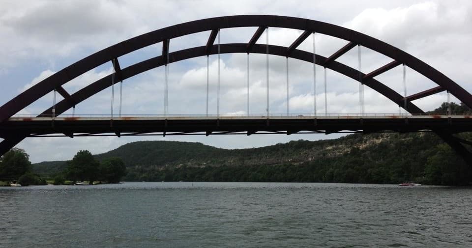 Scenic arched bridge over lake, wide waterside landscape view