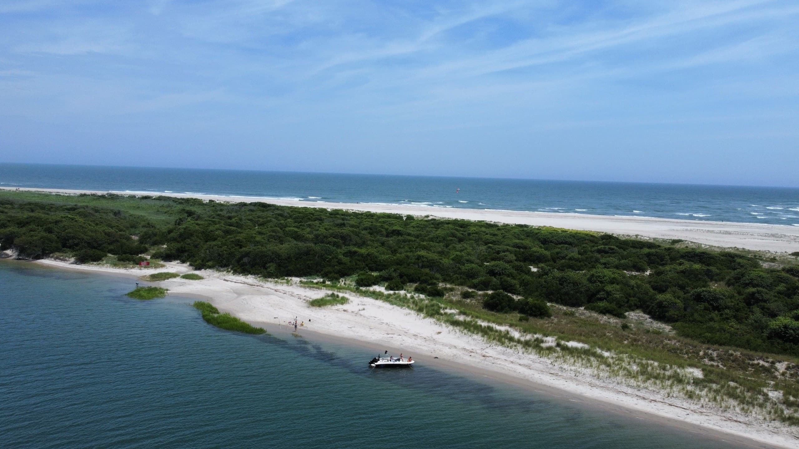 Aerial view of white sand beach and coastal inlet, sunny