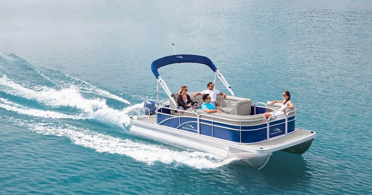 Pontoon boat cruising on turquoise open water with passengers