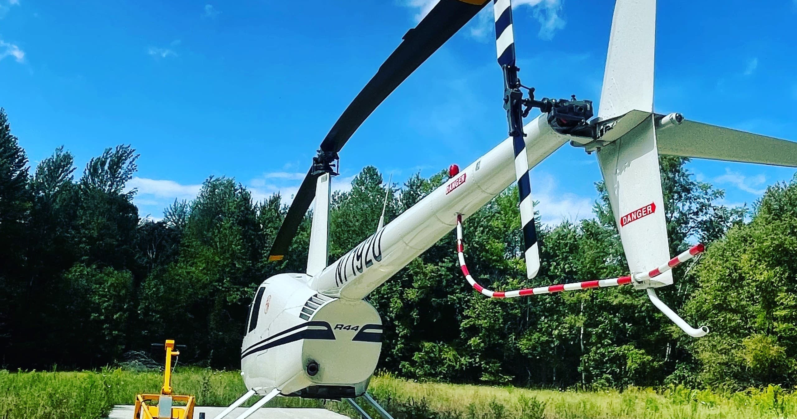 Helicopter parked in meadow with clear sky, outdoor charter photo