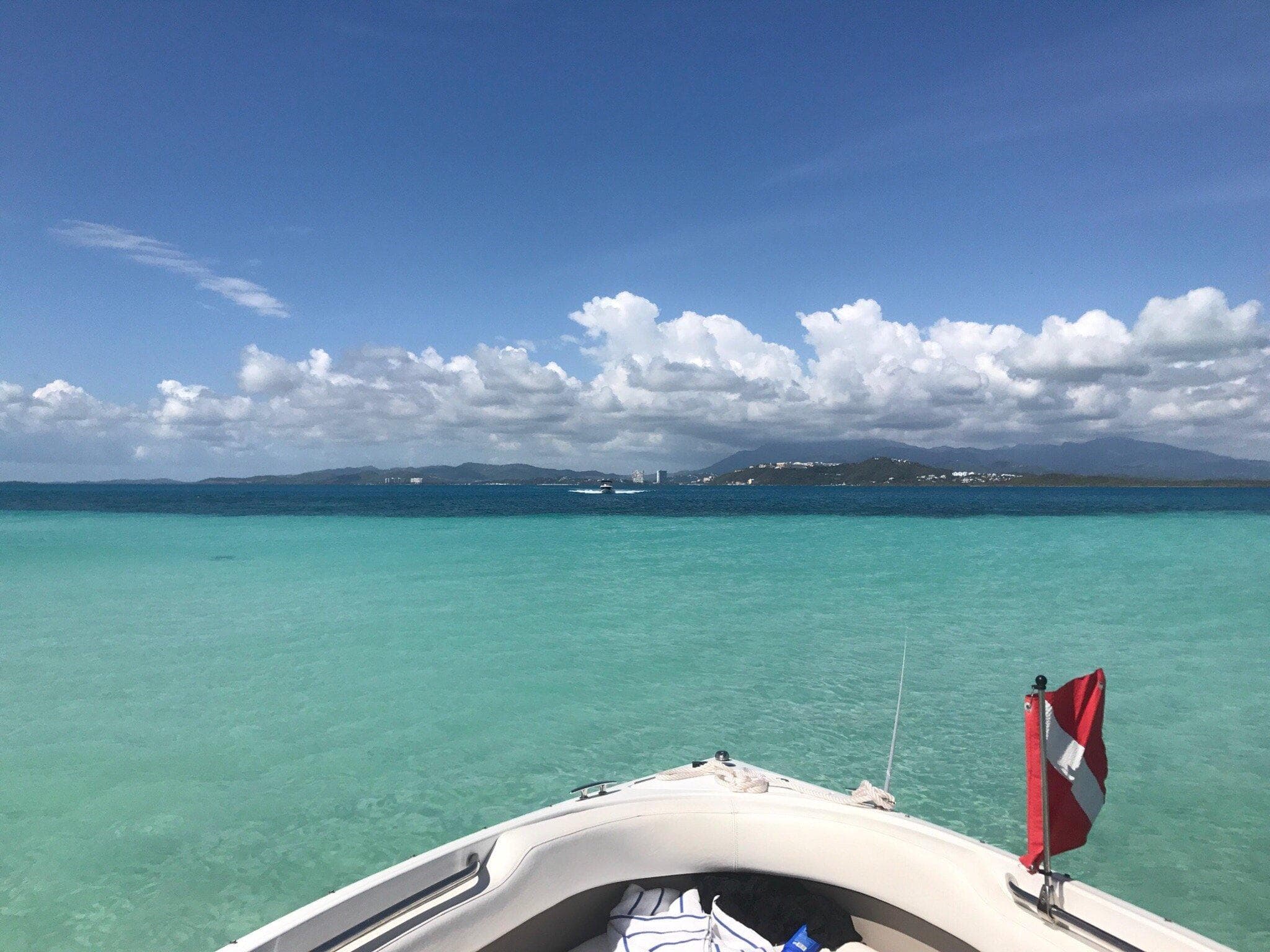 Boat bow over turquoise Caribbean lagoon, scenic snorkeling tour