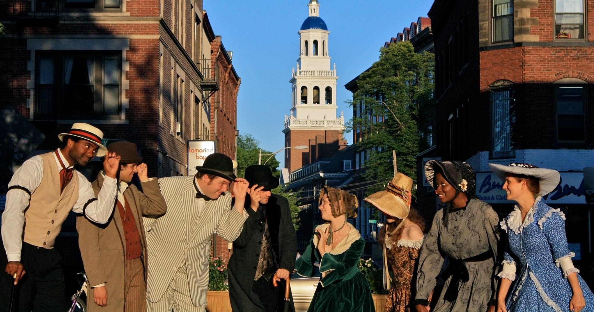 Actors performing a historical street tour by Cambridge church tower