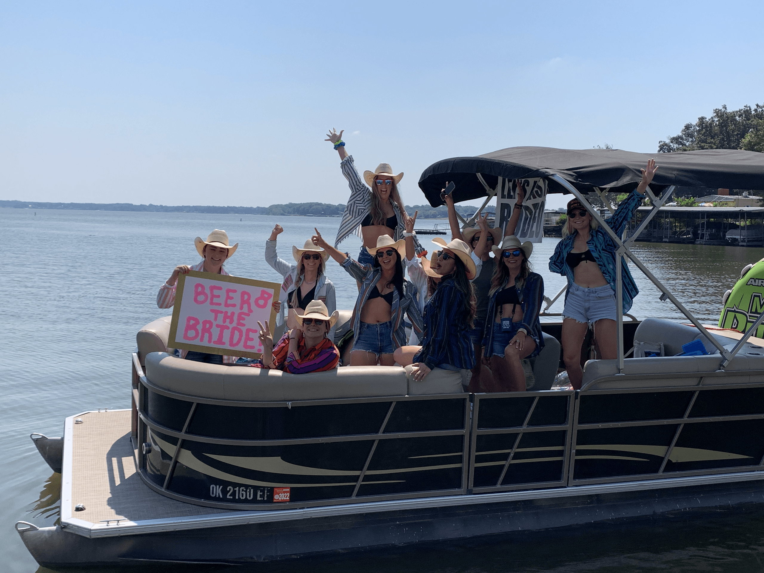 Group of friends on a pontoon boat at a lake celebrating bachelorette