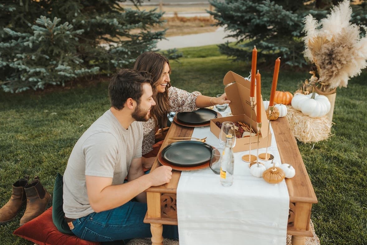 Couple enjoying cozy outdoor picnic at wooden table in park