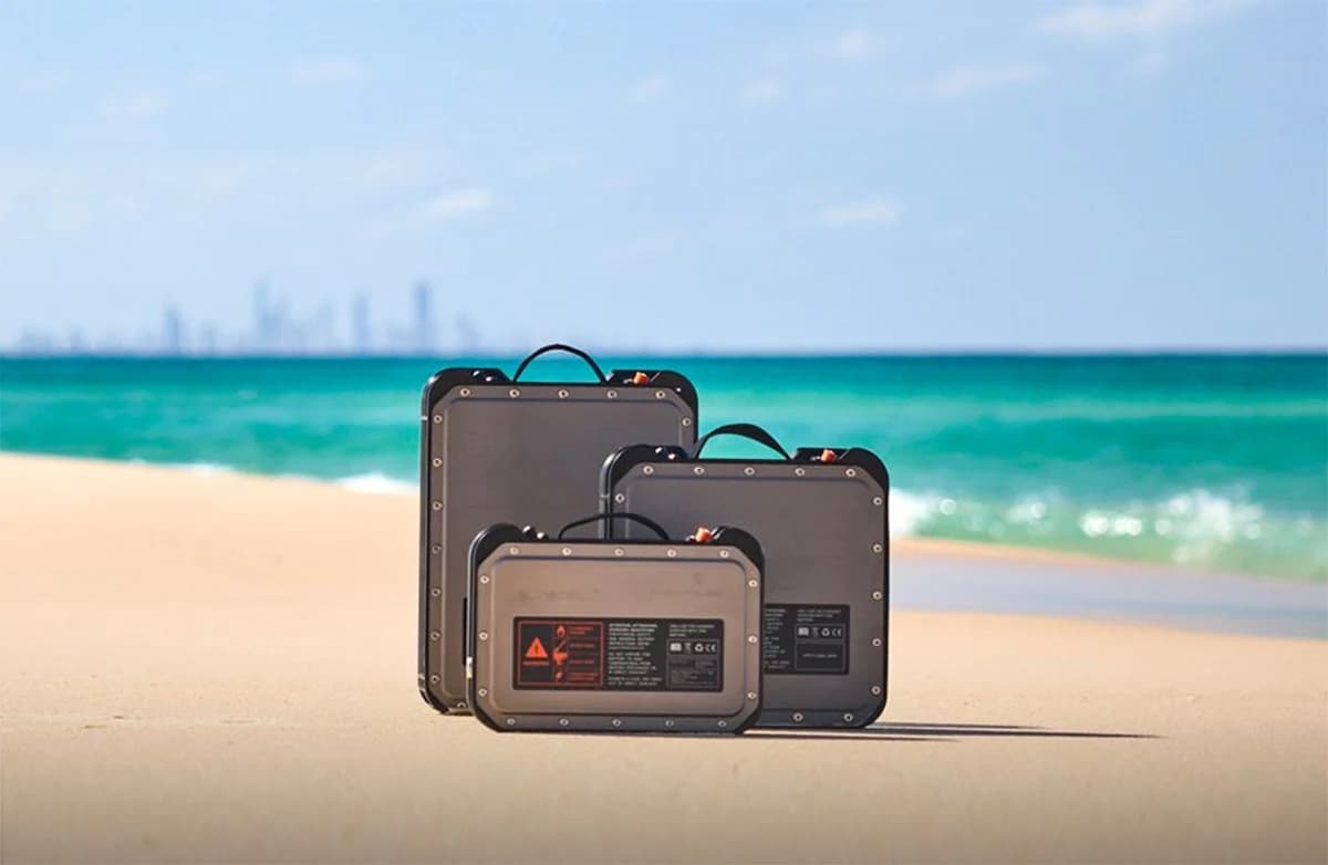 Portable power stations on sandy beach by turquoise ocean, travel