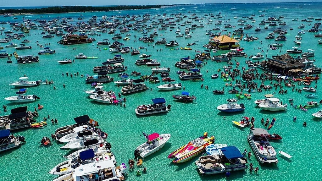 Aerial view of crowded sandbar with dozens of party boats