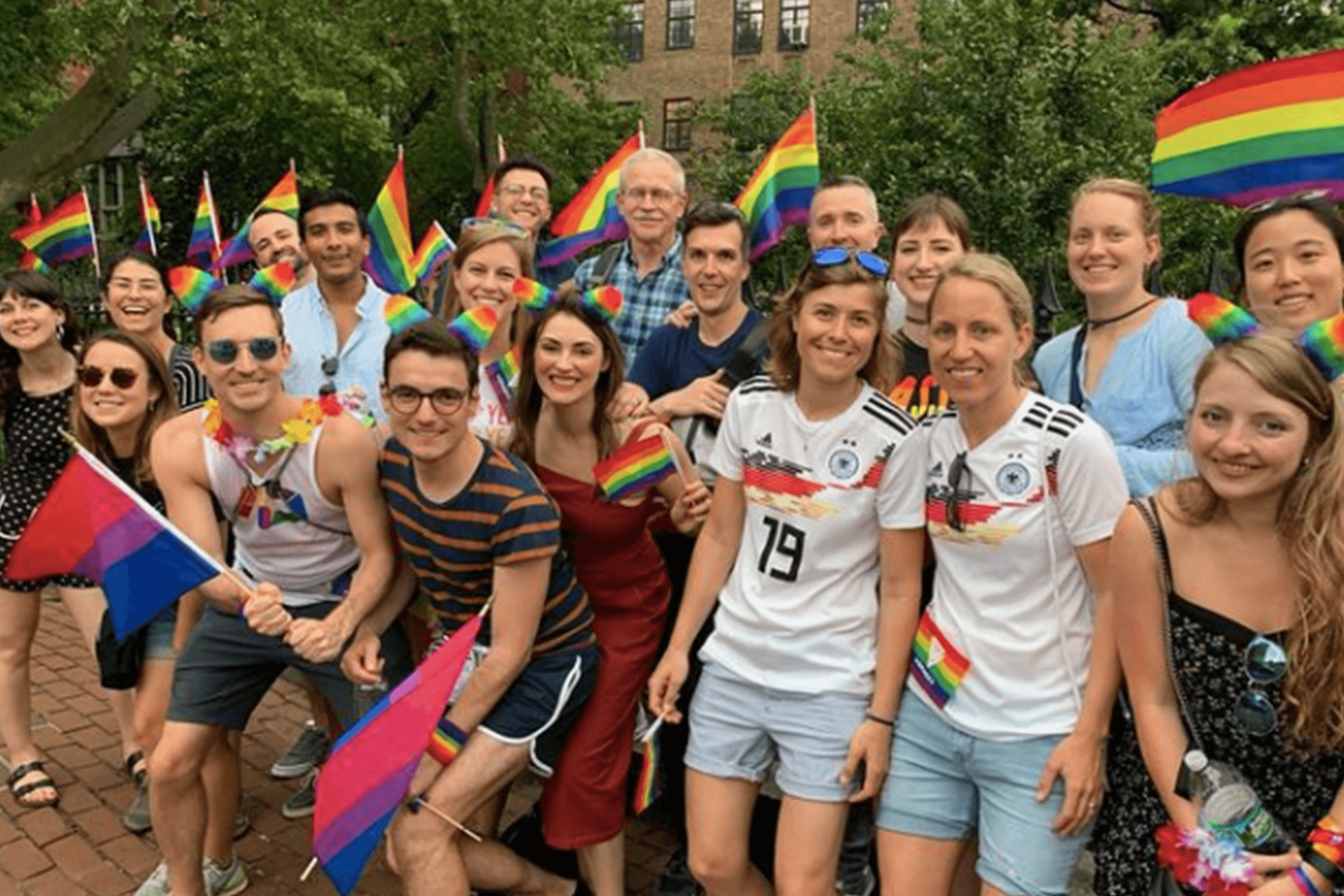 Group walking tour celebrating Pride on urban street