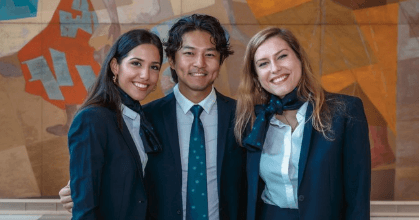 Three delegates smiling indoors at United Nations conference area