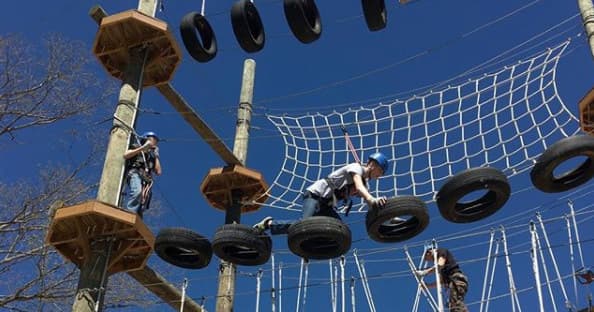 High ropes tire obstacle course against blue sky at aerial course
