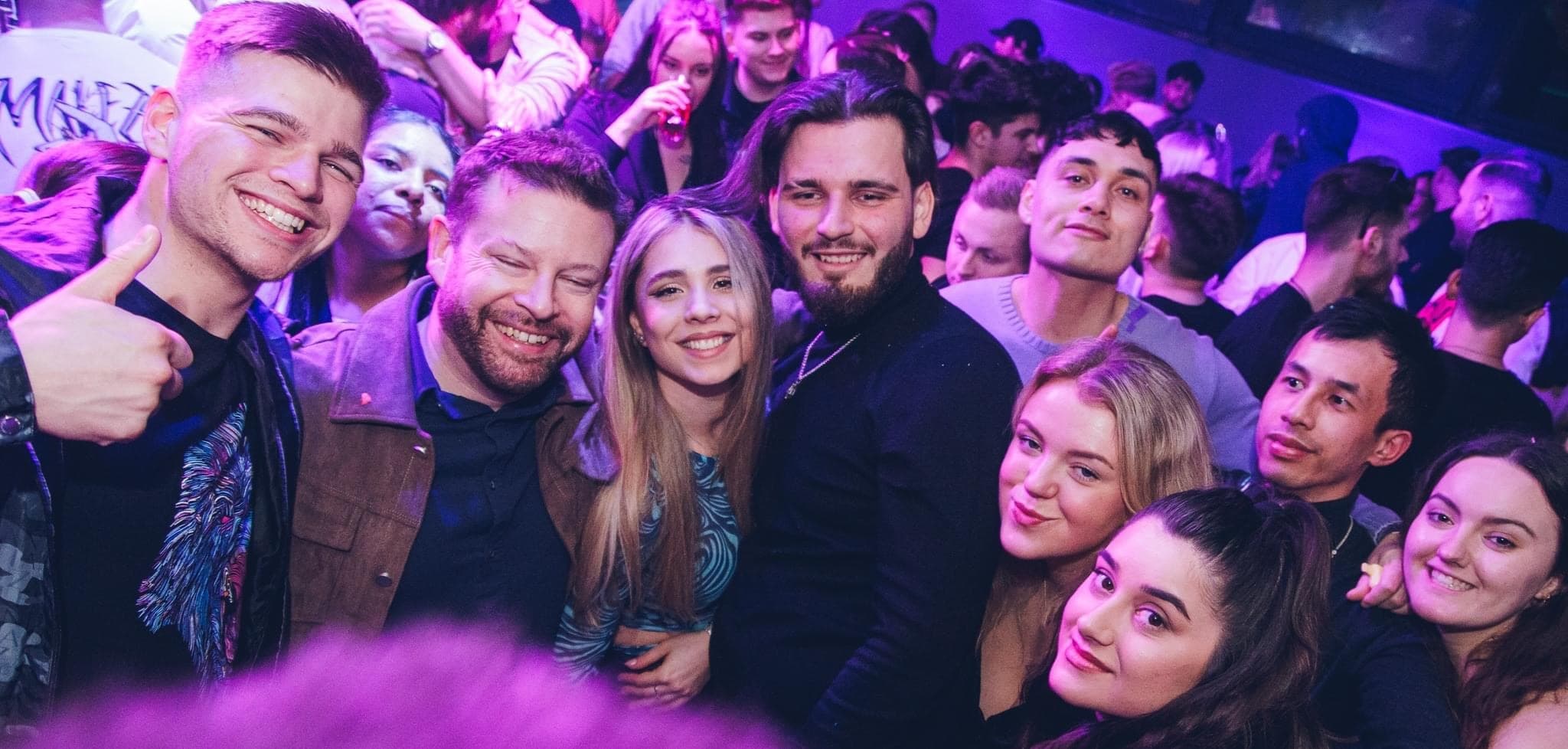 Crowd of young people partying in a Bucharest nightclub group photo