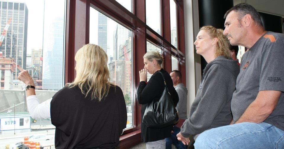 Tourists viewing Manhattan skyline through ferry windows on tour