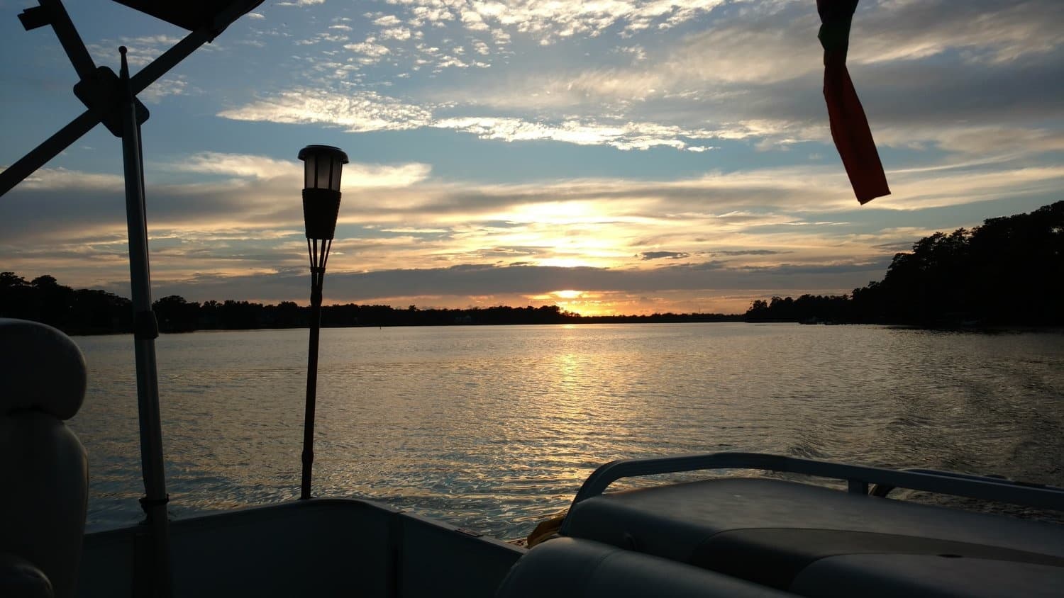 Sunset view from pontoon boat over calm lake waters