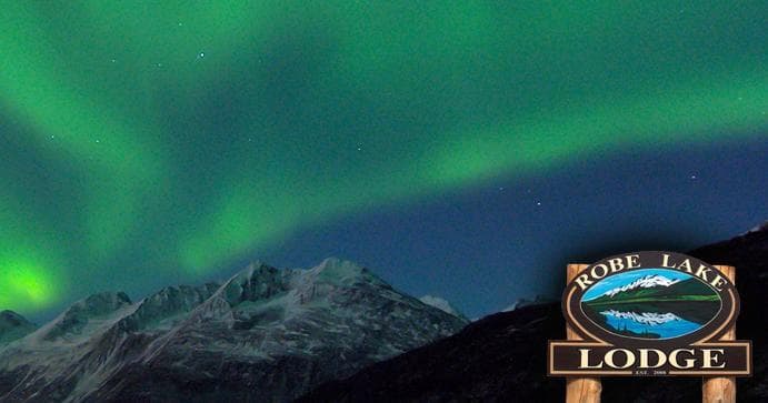 Aurora borealis over mountain lodge for night sky viewing