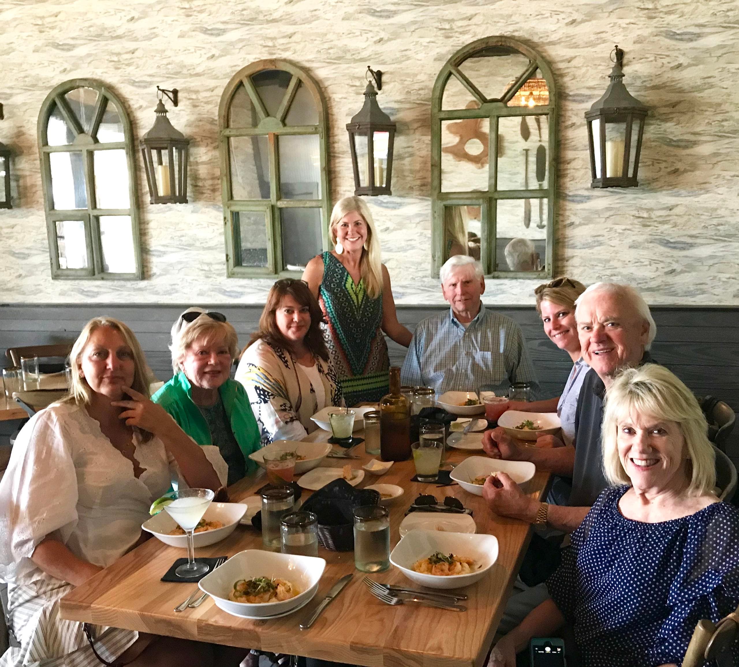Group enjoying rustic riverside restaurant meal in sunlit room