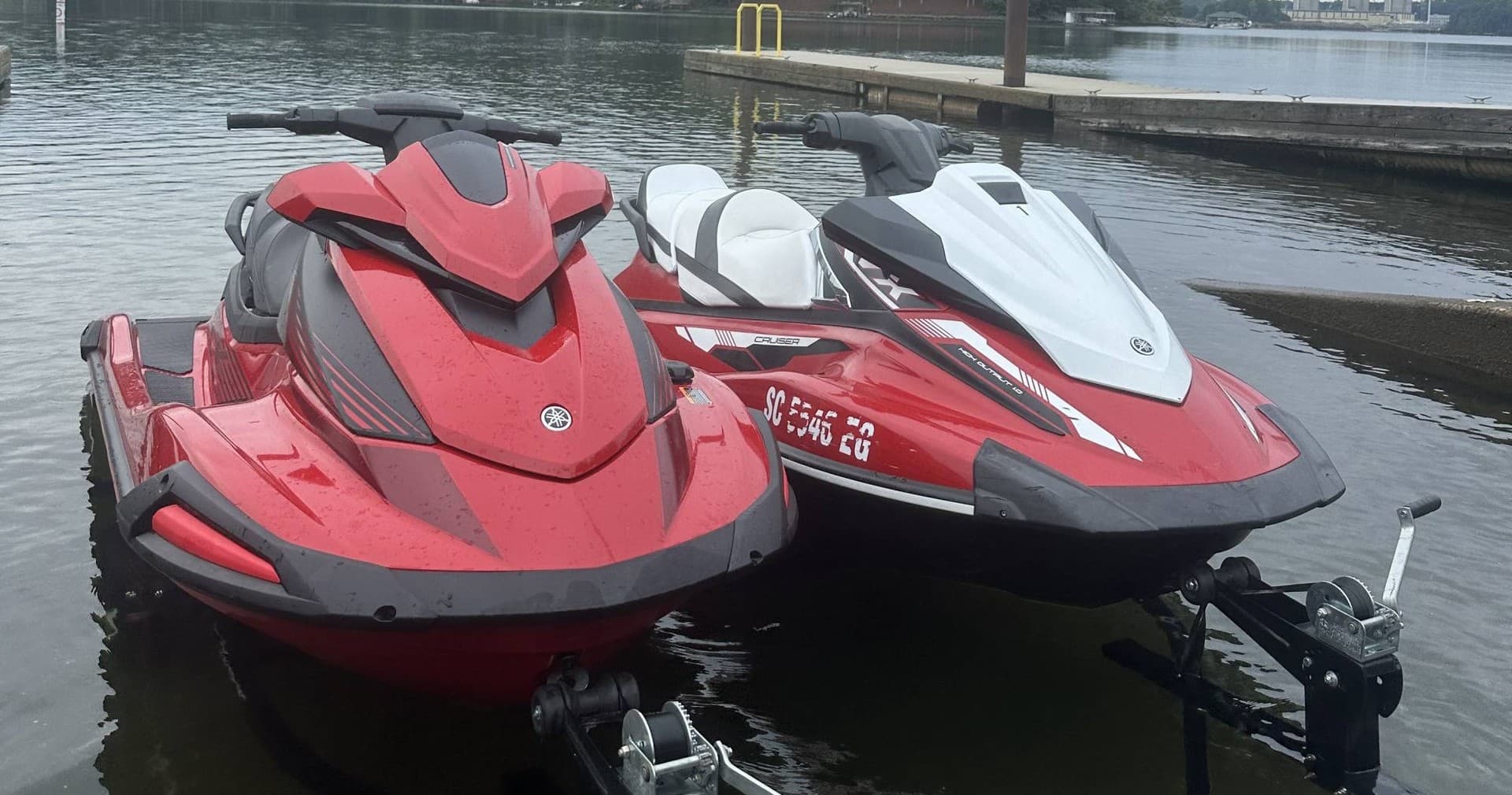 Red and white personal watercraft moored at calm marina pier