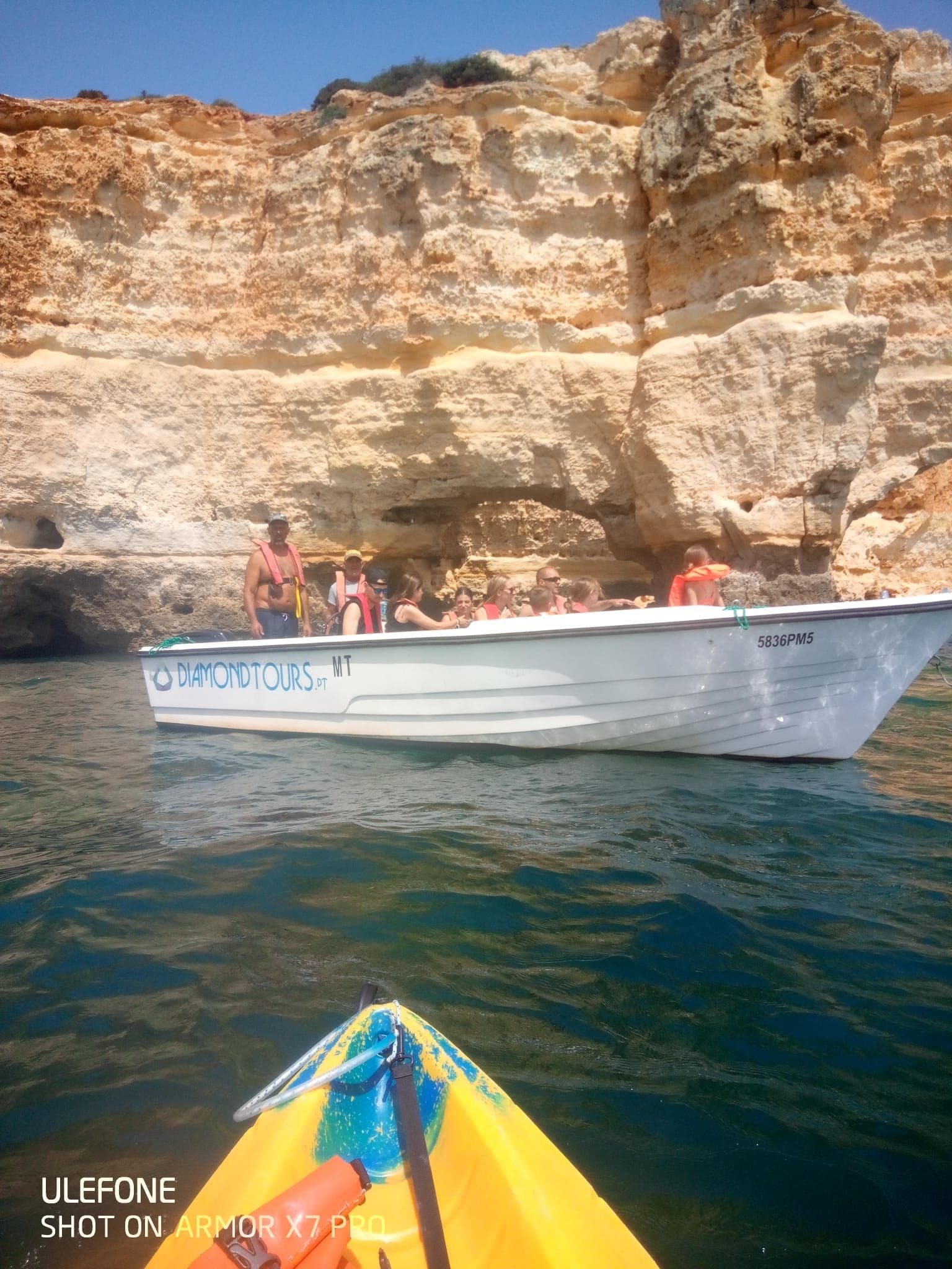 Paddling toward cliffs and tour boat at Benagil sea caves