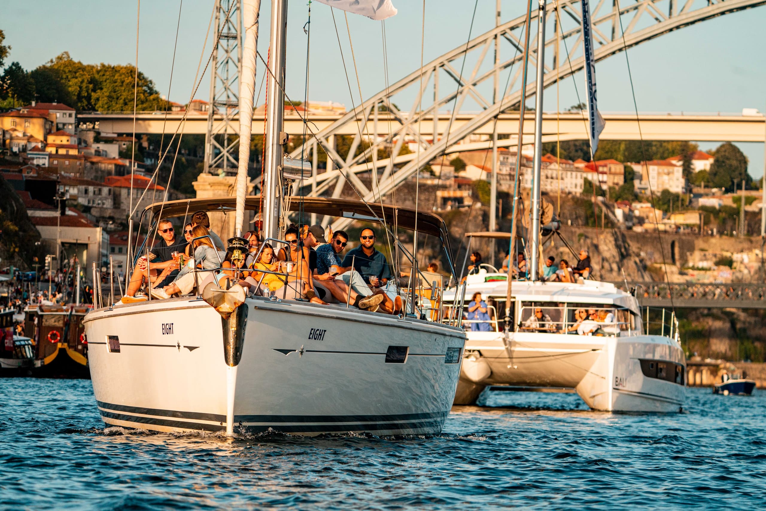 Sailboat flotilla near Porto bridge on calm Douro River