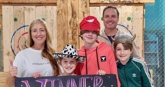 Family posing after axe-throwing win at KissMyAxe Brookvale indoor