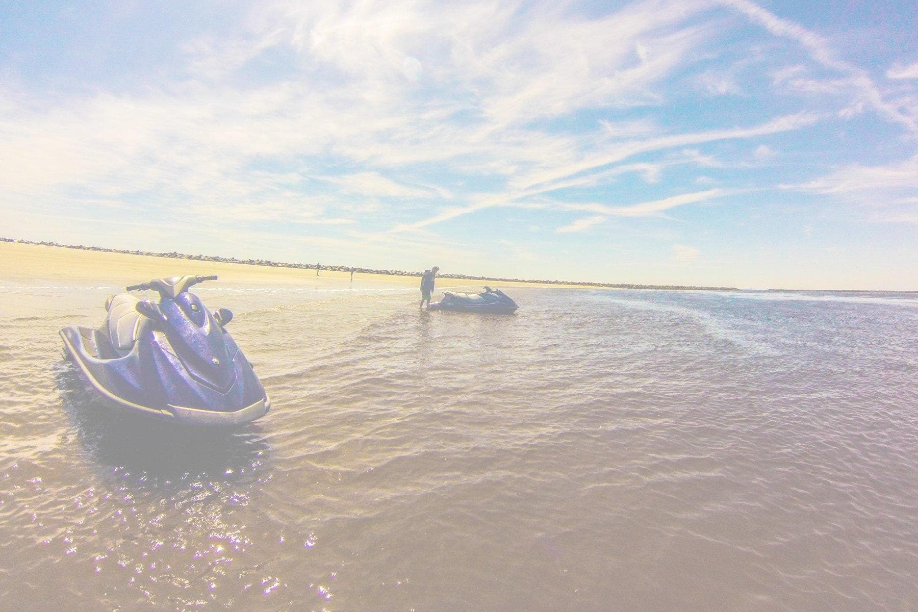 Jetski cruising at sunset over calm ocean near coast