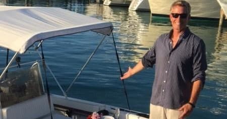 Captain presenting charter boat dockside at marina, boat ready to board