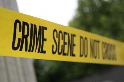 Yellow crime scene tape across outdoor investigation site, caution