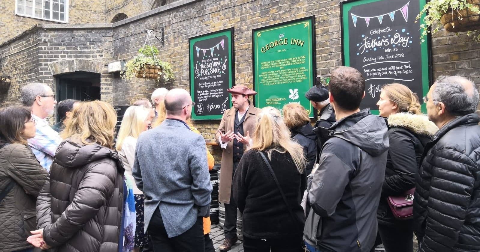 Guide leading a historic outdoor walking tour in London courtyard