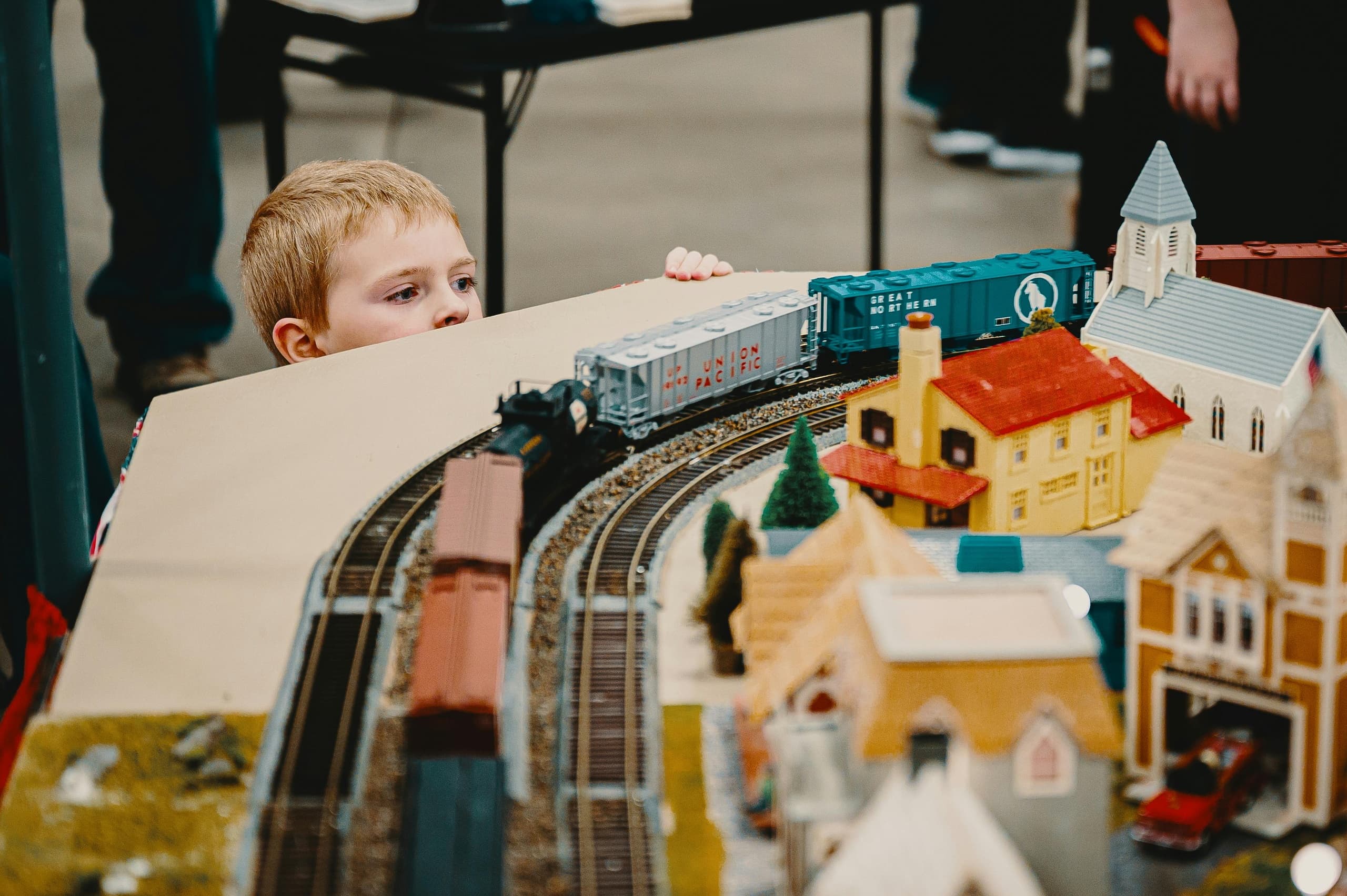 Child watching model train layout at indoor heritage museum exhibit