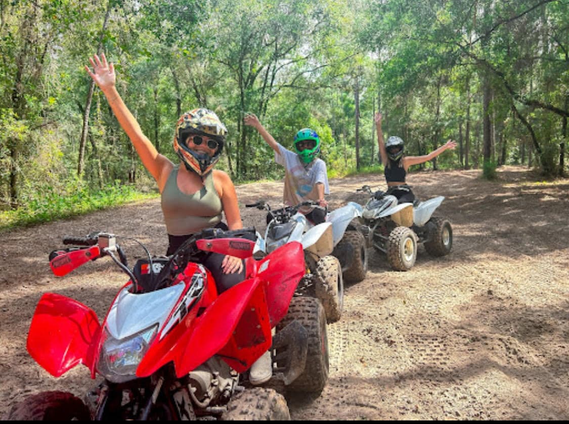 ATV riders on wooded trail in forest, off-road adventure