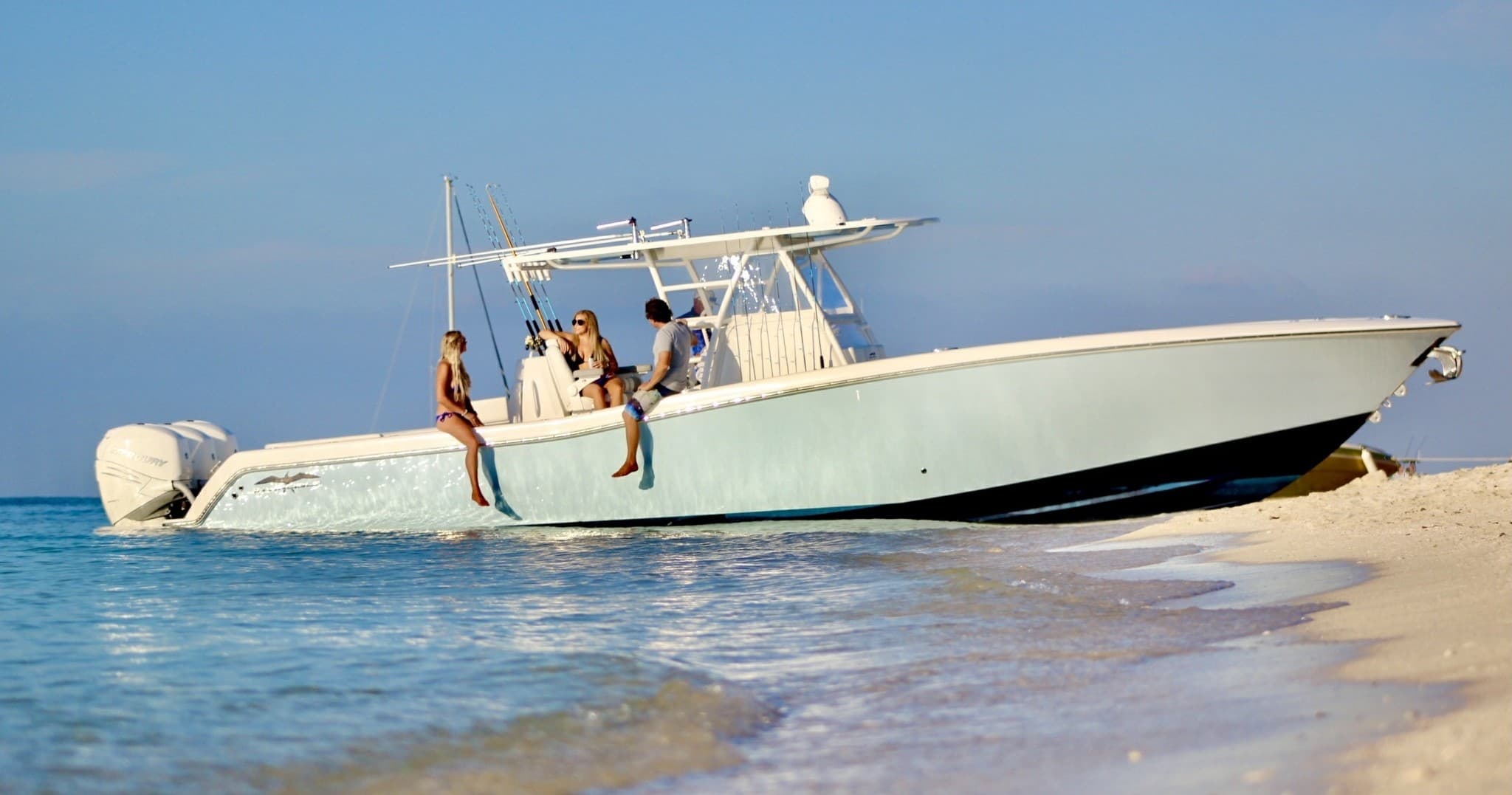 White center-console boat beached on tropical sand near shore