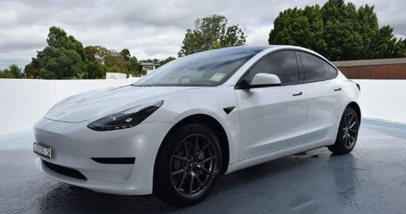 White Tesla Model 3 staged for scenic road-trip rental outdoors