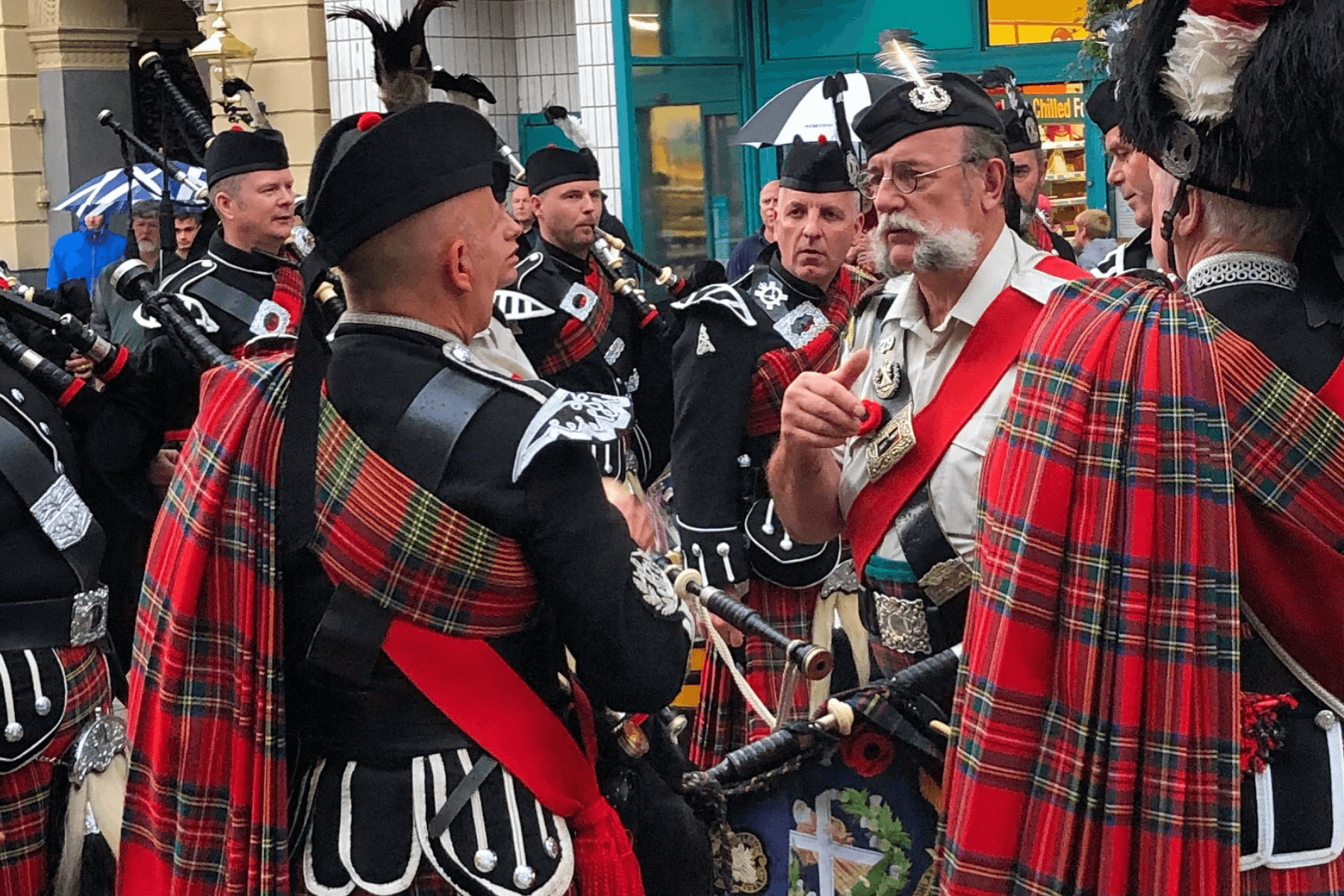 Scottish pipe band performing outdoors on street parade in Inverness
