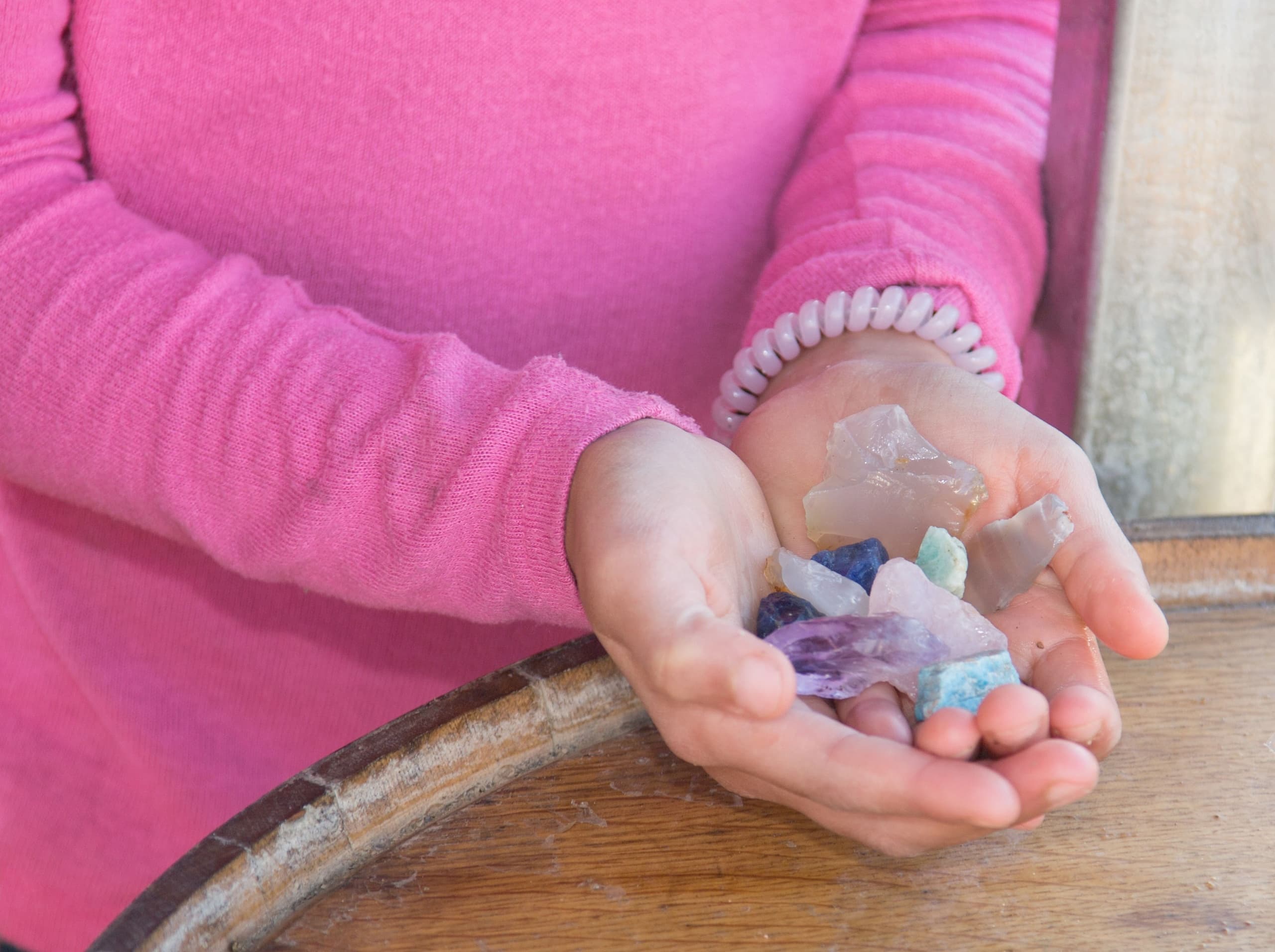 Hands holding colorful gemstones found on Idaho mining tour