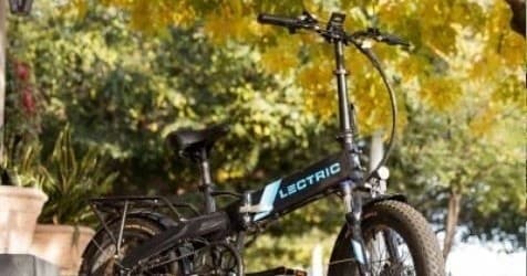 Folded electric bike framed by sunlit trees on Florida Keys path