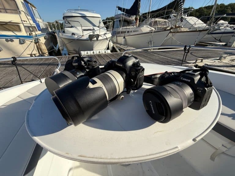 Camera gear laid on boat deck at marina, photography equipment ready