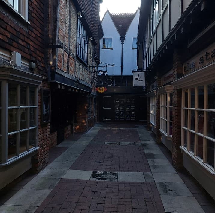 Exploring narrow historic alley between timber-framed buildings