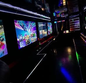 Mobile gaming truck interior with neon screens and consoles