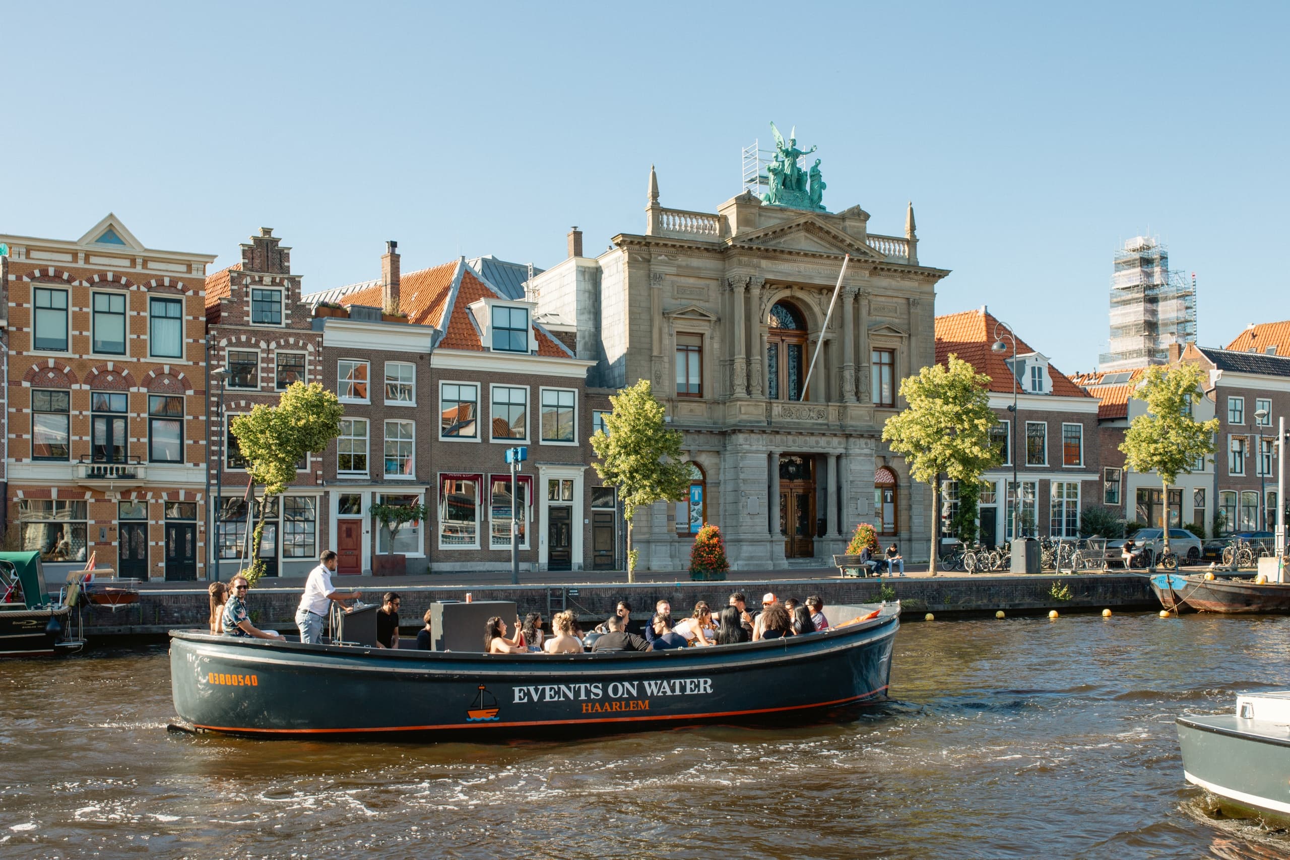 Canal boat cruising past historic Haarlem waterfront buildings