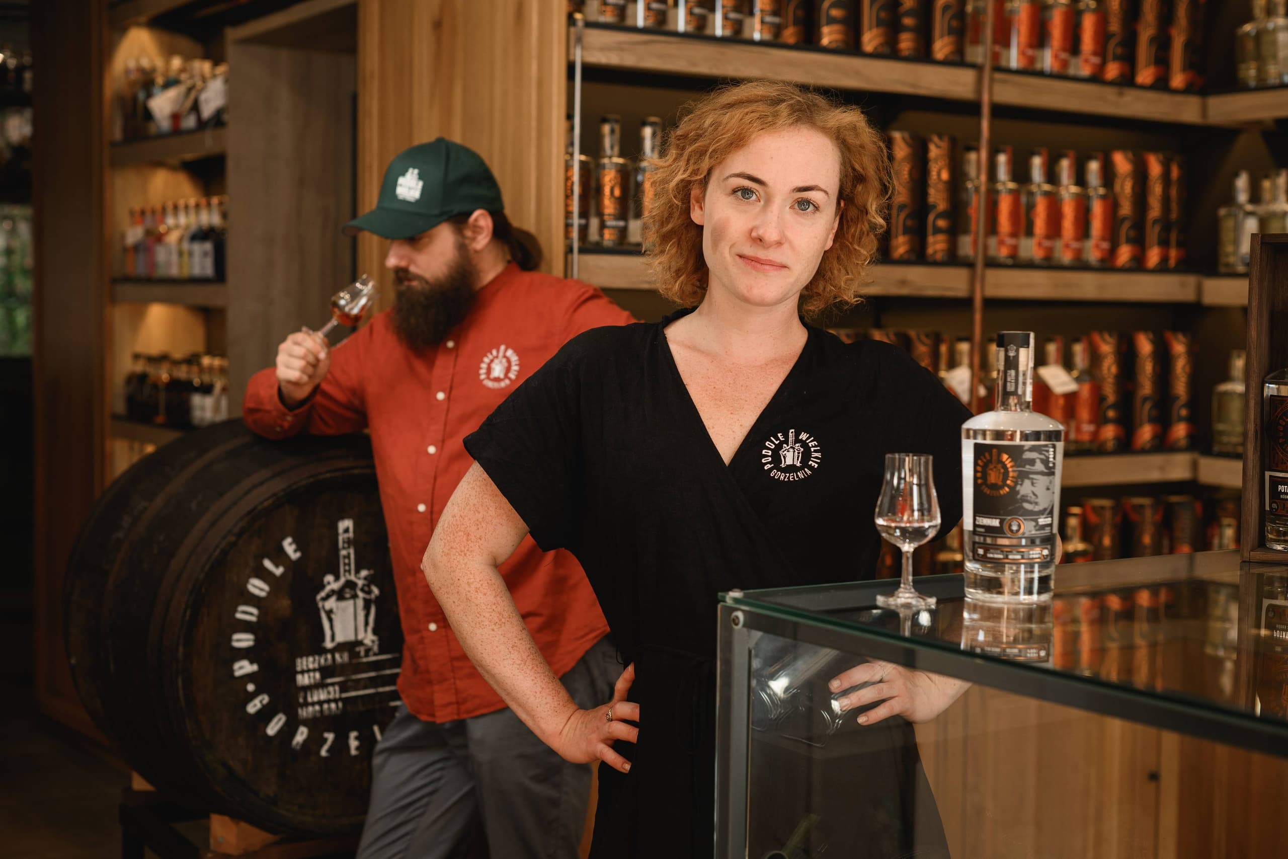 Distillery staff posing in tasting room with barrels and bottles