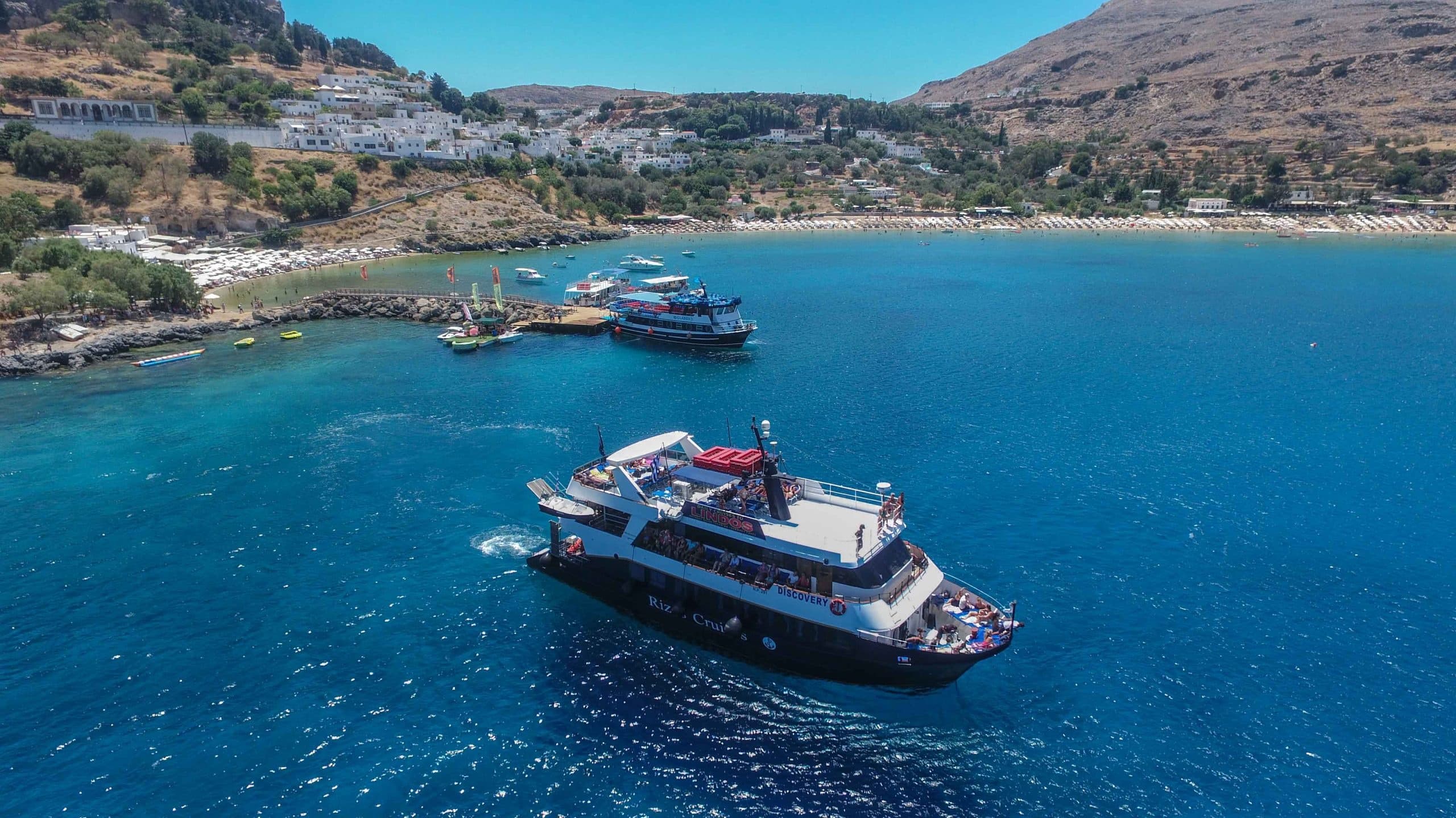 Sightseeing cruise near rocky Mediterranean coastline, aerial view