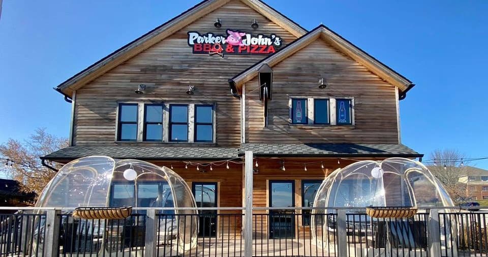 Outdoor restaurant dining in clear bubble domes on wooden lodge