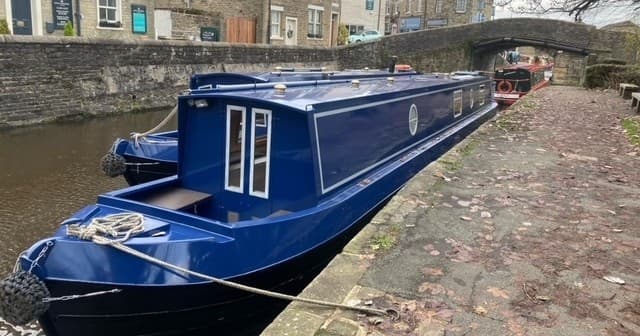 Moored blue narrowboat beside towpath on Lancashire canal