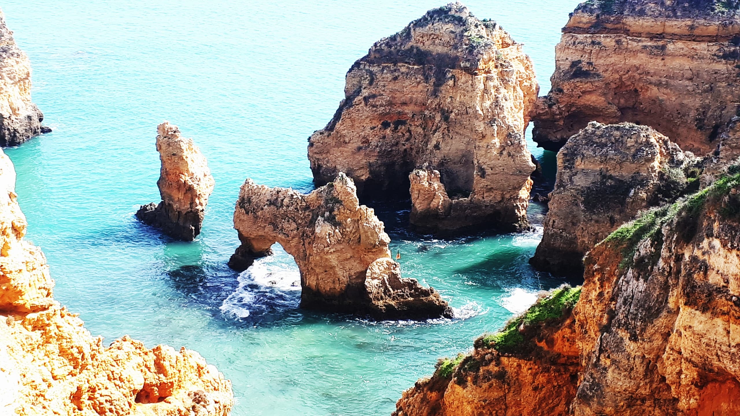 Boat cruising around Algarve sea stacks and coastal grottoes