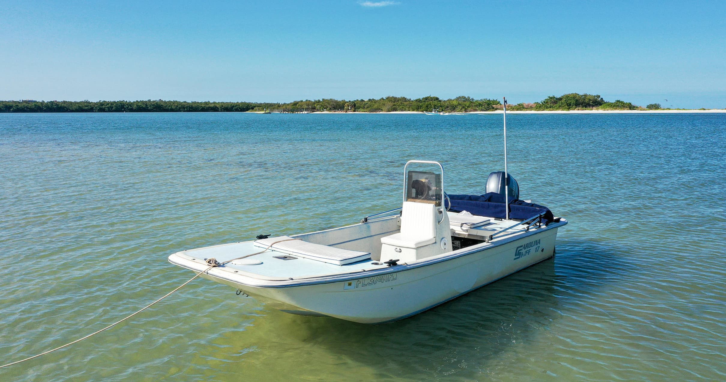 Center-console boat anchored in calm coastal bay for fishing trips