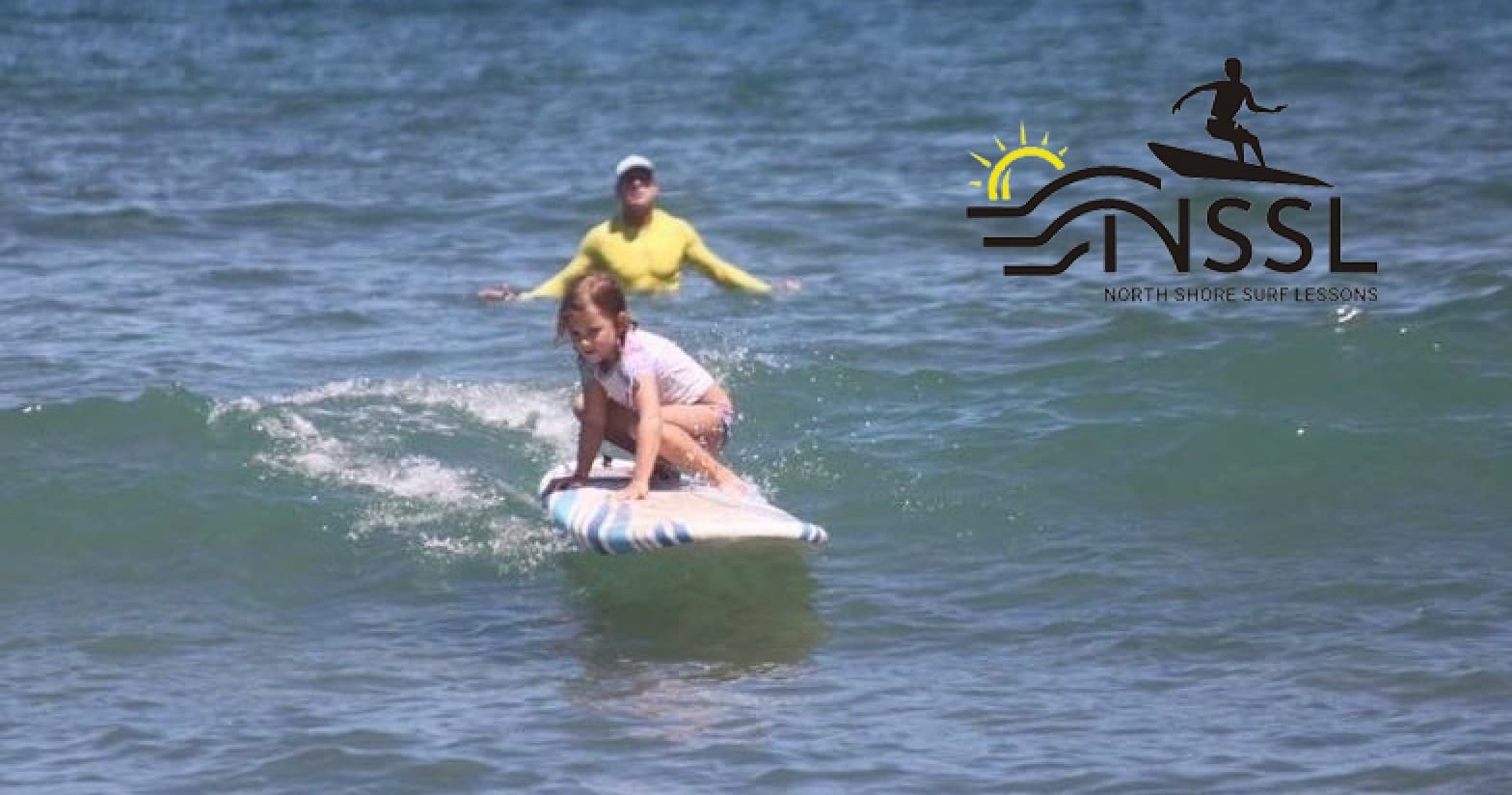 Beginner surfer catching small wave near sandy North Shore