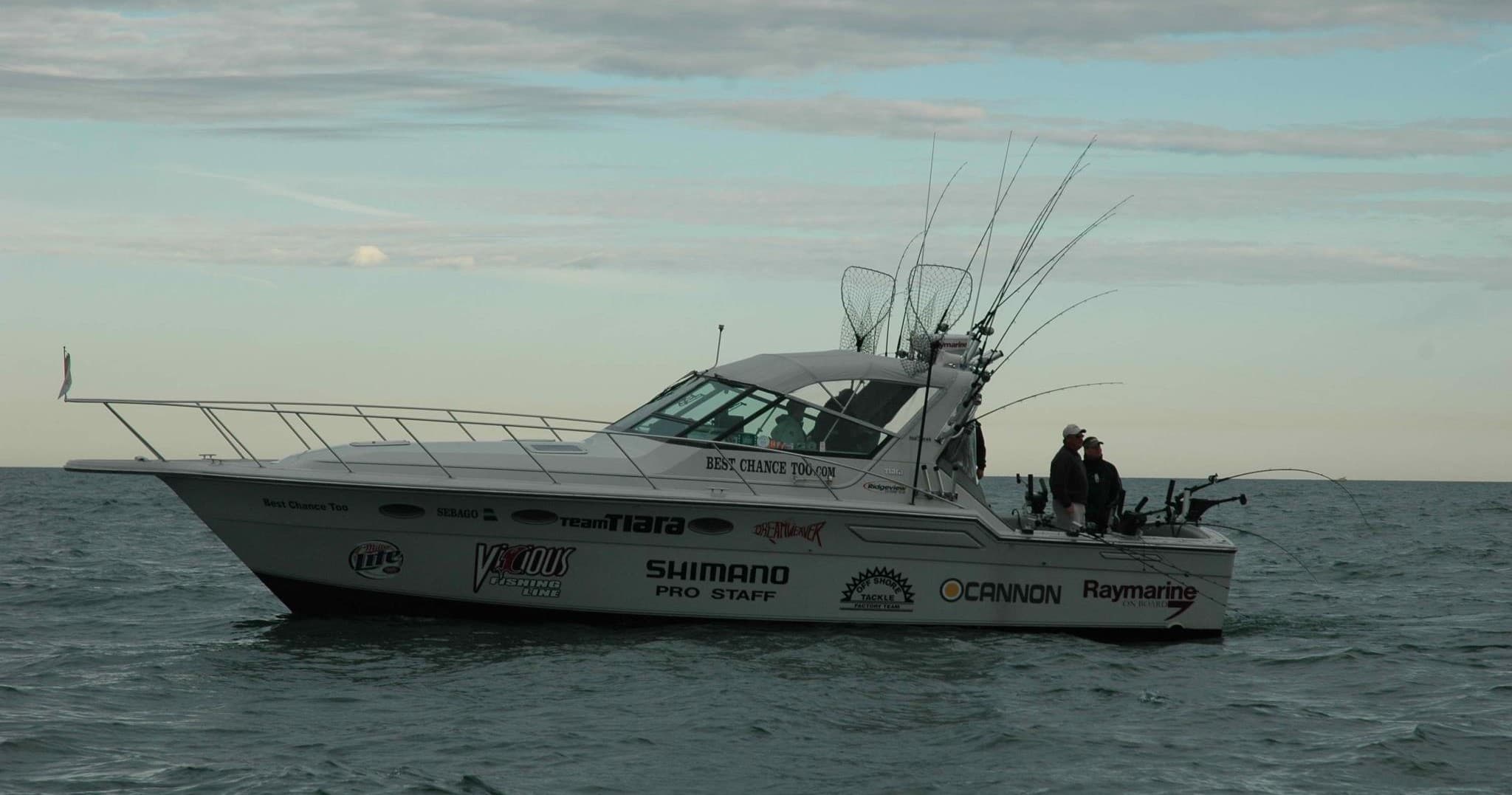 Fishing charter vessel on horizon at sunrise, calm ocean scene