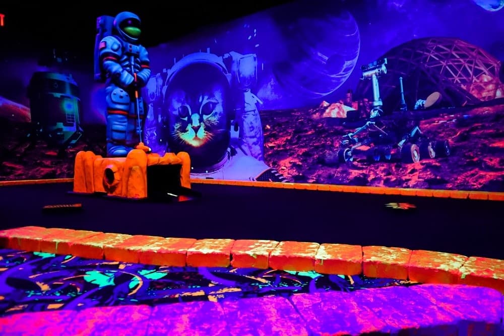 Vibrant cosmic mini golf course view, horizontal neon play area