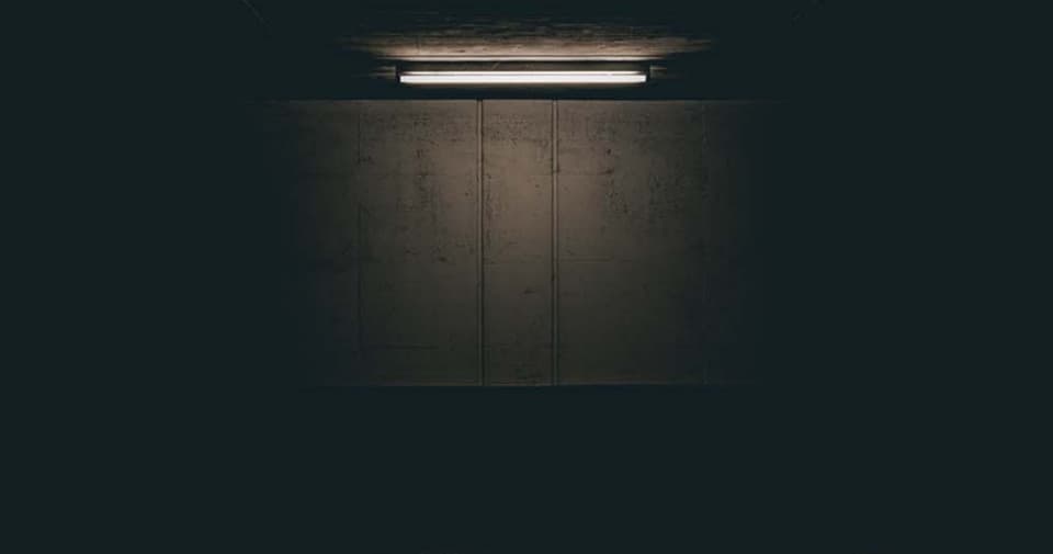 Minimal moody underground corridor with single light, atmospheric space