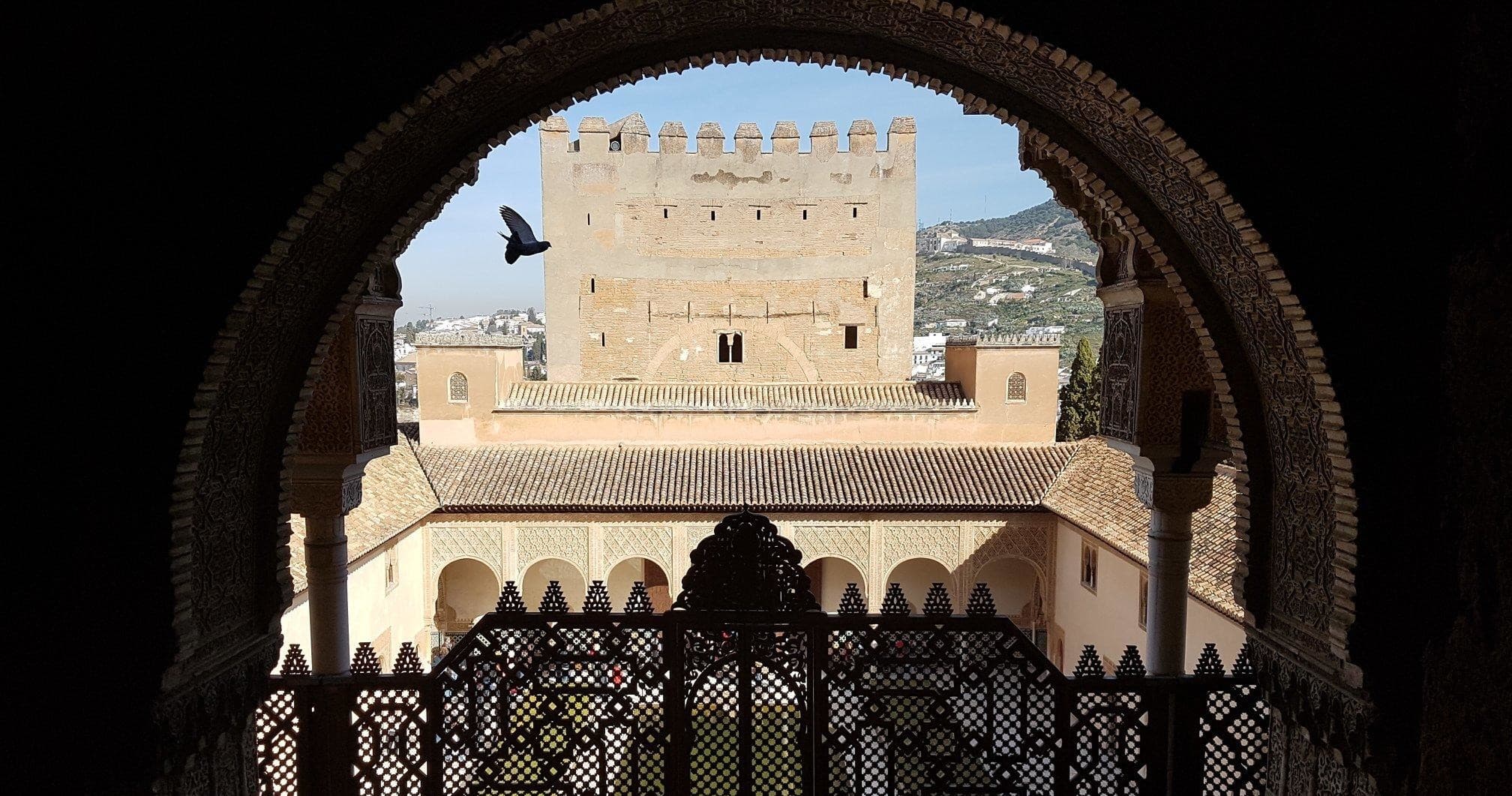 Framed Alhambra fortress view through ornate archway