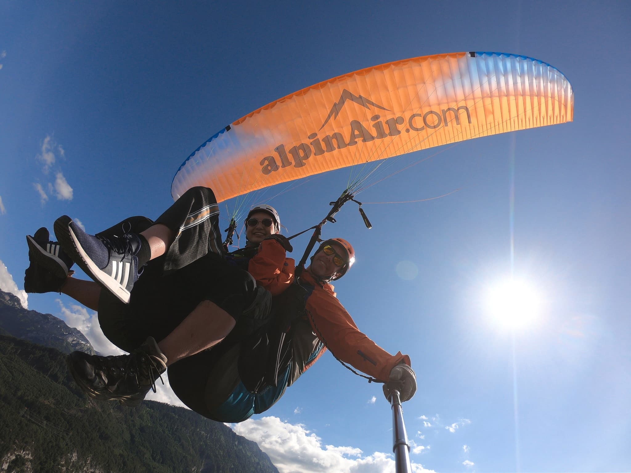 Tandem paragliding flight with pilot and passenger against blue sky