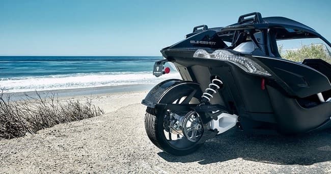 Slingshot parked by sandy beach with ocean view for coastal cruises